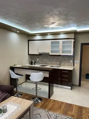 a kitchen with a counter and chairs in a room at Апартамент ВАНЕСА in Velingrad