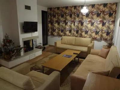 a living room with a couch and a table at Deluxe Apartments in Pamporovo