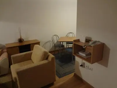 a living room with a chair and a table at Deluxe Apartments in Pamporovo