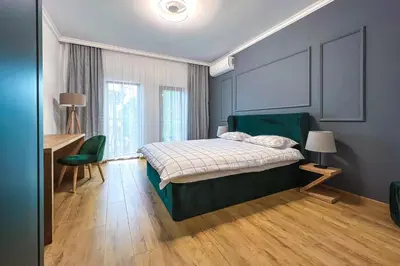 a bedroom with a bed and a desk in it at Deluxe Central Rooms in Karlovo