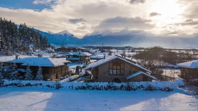 a village covered in snow with mountains in the background at Villa Chalet Everest in Bansko