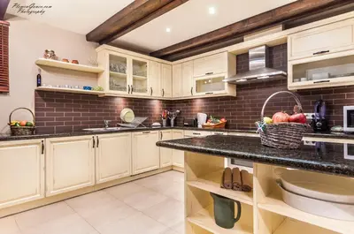 a kitchen with white cabinets and a counter top at Villa Chalet Everest in Bansko