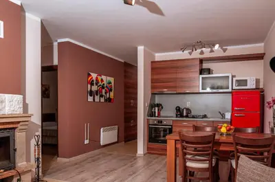 a kitchen with wooden cabinets and a red refrigerator at Stand'Art - апартамент , Смолянски езера in Smolyan