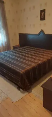 a large bed in a bedroom with a brown bedspread at villa Tia Maria in Hisarya