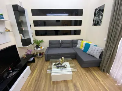 a living room with a couch and a table at Cozy apartment in downtown Sofia - Tsar Samuil Street in Sofia