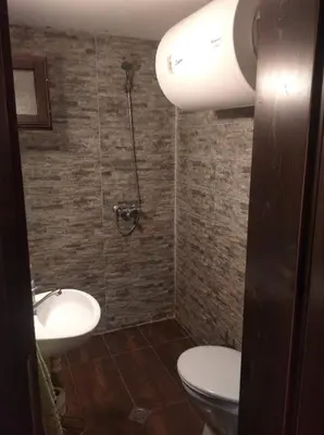 a bathroom with a toilet and a sink and a shower at Room for guests in Smolyan