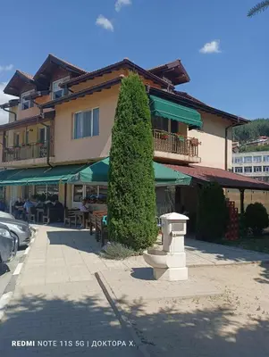 a tall tree in front of a building at Къща за гости-Ганеви in Zmeitsa