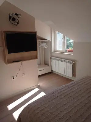 a bedroom with a bed and a flat screen tv at Къща за гости-Ганеви in Zmeitsa