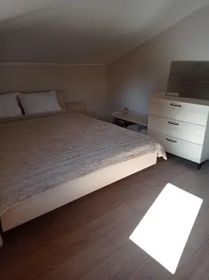 a bedroom with a bed and a dresser with a television at Къща за гости-Ганеви in Zmeitsa