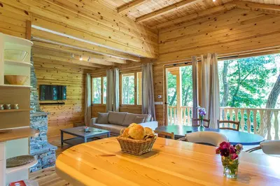 a living room with a table in a log cabin at Garmen Hills Guest Houses in Garmen