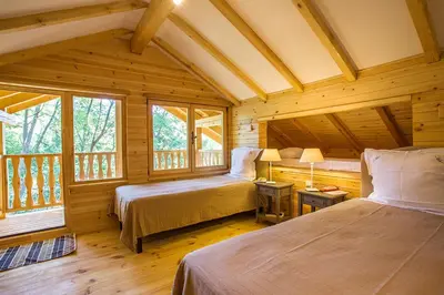 a bedroom with two beds in a log cabin at Garmen Hills Guest Houses in Garmen