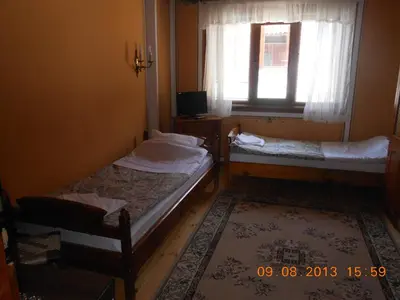 two beds in a small room with a window at Family Hotel Kalina in Koprivshtitsa