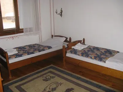 two beds sitting in a room with a window at Family Hotel Kalina in Koprivshtitsa