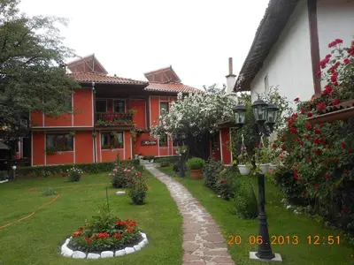 a courtyard of a house with flowers and a street light at Family Hotel Kalina in Koprivshtitsa