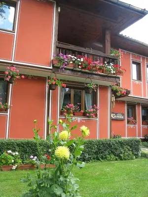 a red building with flower boxes on the windows at Family Hotel Kalina in Koprivshtitsa