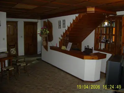 a bar with a staircase in a room with chairs at Family Hotel Kalina in Koprivshtitsa