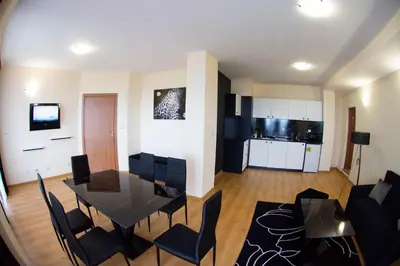 a dining room and living room with a table and chairs at Complex Nero in Pamporovo