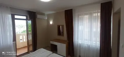 a bedroom with a bed and a window and a mirror at Хотел-ресторант Русаков in Sandanski