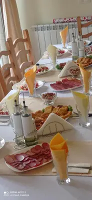 a long table with plates of food on it at Хотел-ресторант Русаков in Sandanski