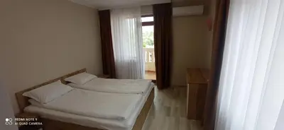 a small room with two beds and a window at Хотел-ресторант Русаков in Sandanski