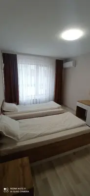 a bedroom with two beds and a window at Хотел-ресторант Русаков in Sandanski
