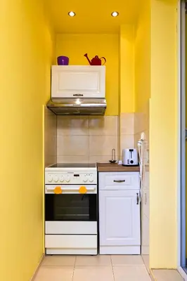 a kitchen with a white stove and a yellow wall at The Cozy Home 1-Bedroom in Central Plovdiv by Flat Mаnager in Plovdiv