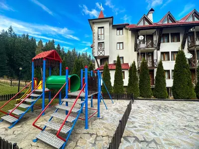 a playground in front of a large building at Castle Romance - Pamporovo in Pamporovo