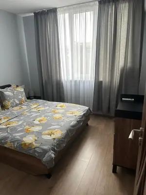 a bedroom with a bed with a blue blanket with yellow flowers at Rose in Karlovo