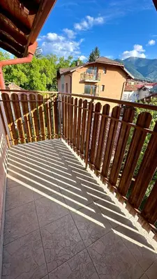 a balcony with a wooden fence and a building at Kaloyanova House Bansko in Bansko