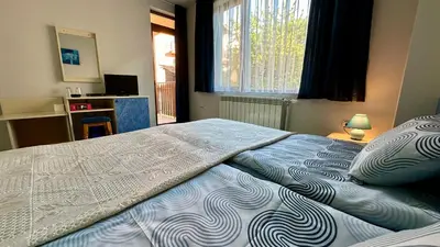 a large bed in a bedroom with a window at Kaloyanova House Bansko in Bansko