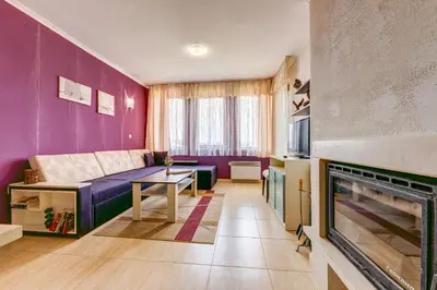 a living room with a couch and a fireplace at Colorful 2BD Apartment with Indoor Fireplace and Mountain View by Flat Mаnager in Pamporovo