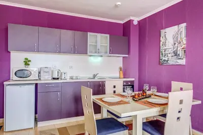 a kitchen with purple walls and a table and chairs at Colorful 2BD Apartment with Indoor Fireplace and Mountain View by Flat Mаnager in Pamporovo