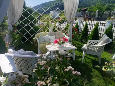 a patio with a couch and a table and chairs at Белият кът in Sapareva Banya