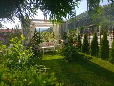 a garden with a white pergola and a table at Белият кът in Sapareva Banya