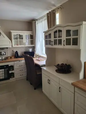 a kitchen with white cabinets and a desk with a chair at Белият кът in Sapareva Banya