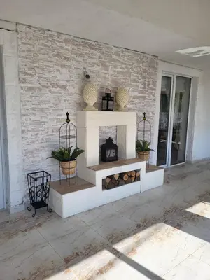 a living room with a fireplace on a brick wall at Белият кът in Sapareva Banya