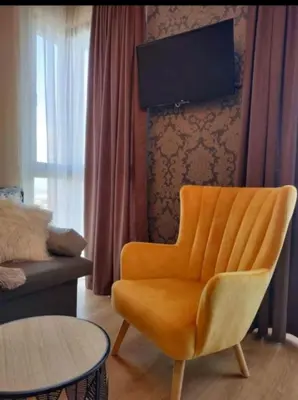 an orange chair in a living room with a tv at Luxury Suite Ivana in Bansko