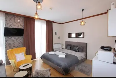 a bedroom with a bed and a chair at Luxury Suite Ivana in Bansko