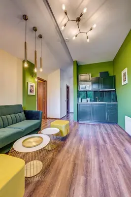 a living room with green walls and a couch and tables at Boho Mountain Studio in Smolyan