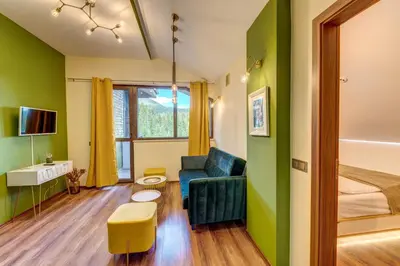 a room with green walls and a couch and a bed at Boho Mountain Studio in Smolyan