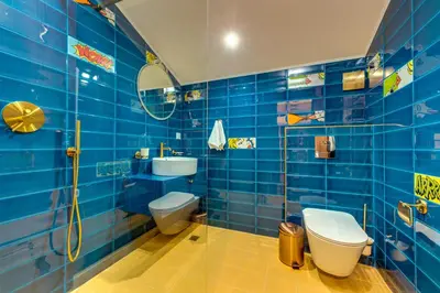 a blue tiled bathroom with a toilet and a sink at Boho Mountain Studio in Smolyan