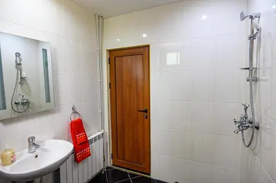 a bathroom with a sink and a wooden door at Guest House Dinaya in Dobrinishte