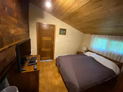 a bedroom with a bed and a desk with a computer at Къща за гости 
