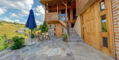an outdoor patio with an umbrella and a building at Къща за гости 