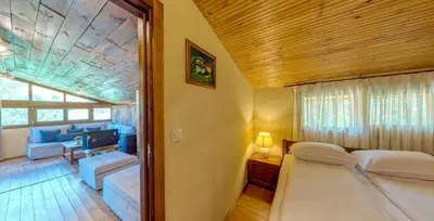 a bedroom with a bed and a living room at Къща за гости 