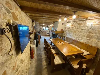 a dining room with a wooden table and chairs at Къща за гости 