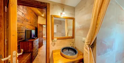 a bathroom with a tv and a tub in it at Къща за гости 