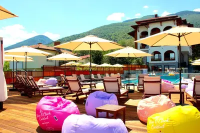 a group of chairs and umbrellas next to a pool at EMAR HOTEL & SPA in Sapareva Banya
