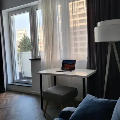 a laptop on a desk in a room with a window at New luxury apartment next to subway with garage in Sofia