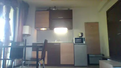 a kitchen with a table and a refrigerator and a microwave at Alexander 3327 in Bansko